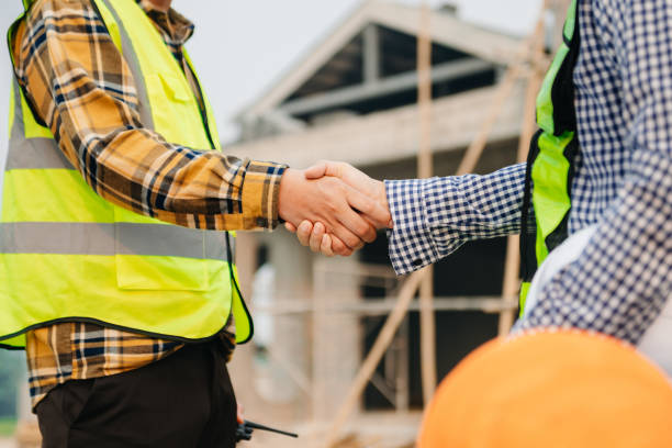 Engineer and contractor join hands after signing contract, They are having a modern building project together. successful cooperation concept in sun light